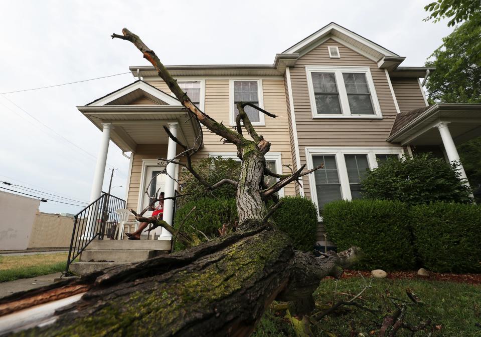 A woman sat on her porch after a tree fell in the front yard of her duplex near the intersection of South Shelby Street and Marshall Street during a storm that moved through Louisville, Ky., on July 6, 2022.