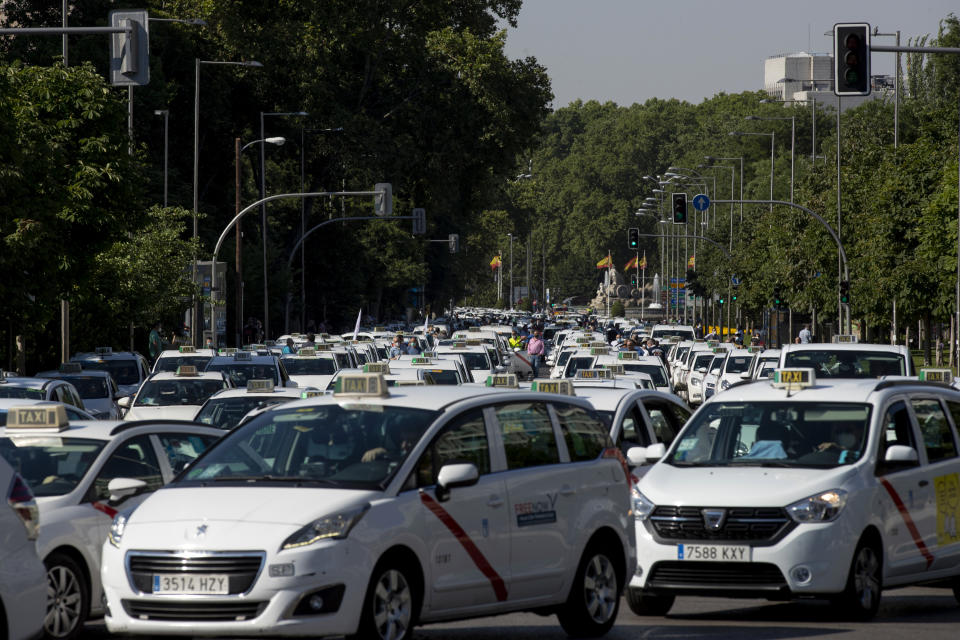 Taxi drivers block a main avenue during a taxi driver protest in downtown Madrid, Spain, Tuesday, June 30, 2020. Taxi drivers are demanding assistance due to lack of clients and private hire. (AP Photo/Manu Fernandez)