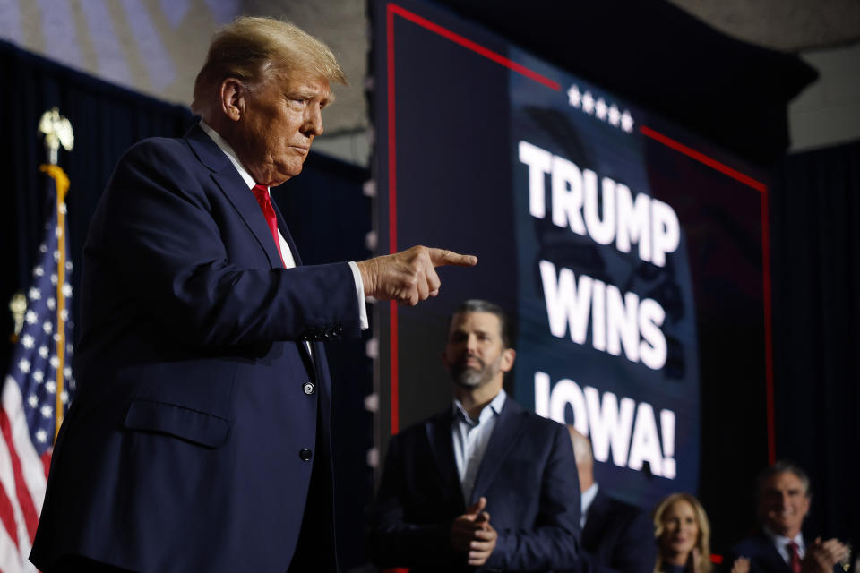 Former President Donald Trump points to his supporters during his evening event in Des Moines, Iowa.