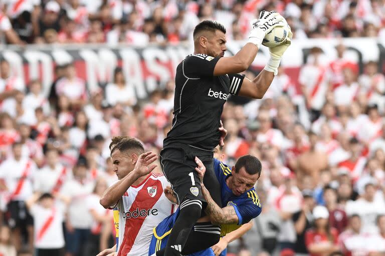 Sergio Romero atrapa la pelota en las alturas, entre Leandro González Pirez y Cristian Lema, durante el último superclásico