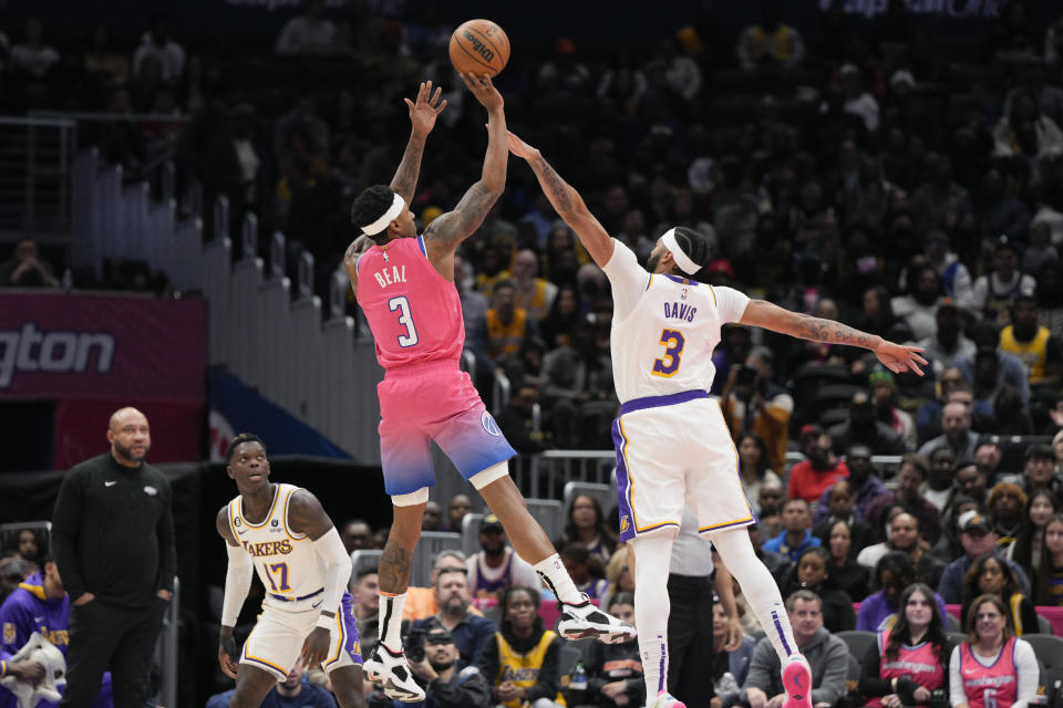 Washington Wizards guard Bradley Beal, center left, shoots to score against Los Angeles Lakers forward Anthony Davis, right, during the first half of an NBA basketball game, Sunday, Dec. 4, 2022, in Washington. (AP Photo/Jess Rapfogel)