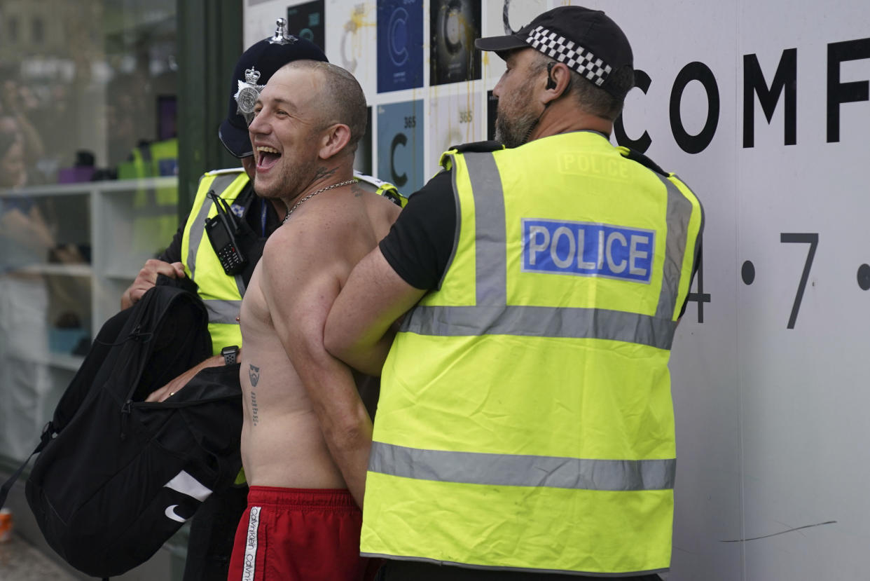 A man is detained by police officers during a protest in Nottingham 