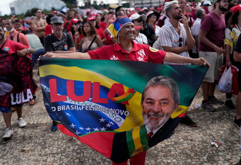 Una simpatizante del nuevo presidente Luiz Inácio Lula da Silva extiende una manta durante su investidura el domingo 1 de enero de 2023, frente al palacio presidencial de Planalto, en Brasilia