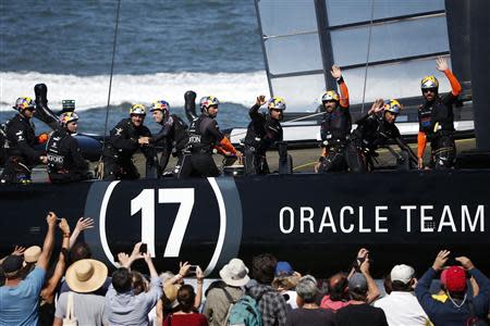 Members of Oracle Team USA wave to spectators after the postponement of Race 13 of the 34th America's Cup yacht sailing race in San Francisco, California September 19, 2013. REUTERS/Stephen Lam