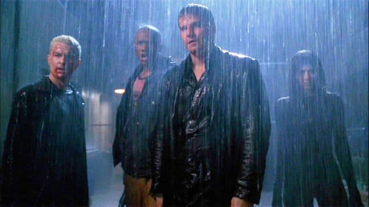 Four people stand in the rain in Angel.