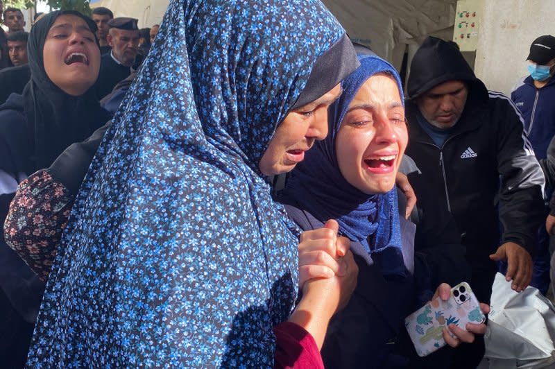 The widow (R) is supported by a relative during the funeral of Hamza Wael Dahdouh, a journalist with the Al Jazeera television network, who was killed in a reported Israeli air strike in Rafah in the Gaza Strip on Sunday. Secretary Antony Blinken kicked off a Middle Eastern diplomatic push as the Israeli-Gaza conflict is threatening to expand into a regional war. Photo by Ibrahim Al-Khatib/UPI