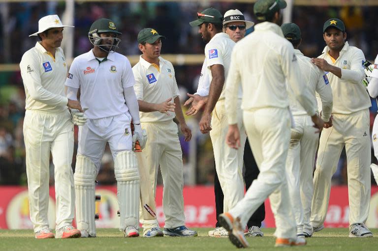 Bangladesh's Shakib Al Hasan (2nd L) shakes hands with Pakistan captain Misbah-ul-Haq (L) at close of play on the fifth and final day of the first Test match in Khulna on May 2, 2015