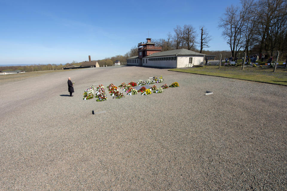 Volkhard Knigge, foundation director of the Nazi concentration camp Buchenwald memorial place, lays down a flower during a minute's silence in memory of the victims at the 75th anniversary of the liberation of the former Nazi concentration camp Buchenwald by the US Army near Weimar, Germany, Saturday, April 11, 2020. Because of Corona crisis, the memorial is currently closed and all commemoration ceremonies with survivors have been cancelled. For most people, the new coronavirus causes only mild or moderate symptoms, such as fever and cough. For some, especially older adults and people with existing health problems, it can cause more severe illness, including pneumonia. (AP Photo/Jens Meyer)