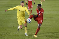 Toronto FC's Richie Laryea, right, controls the ball as Nashville SC's Alex Muyl defends during the first half of an MLS soccer playoff match Tuesday, Nov. 24, 2020, in East Hartford, Conn. (AP Photo/Jessica Hill)