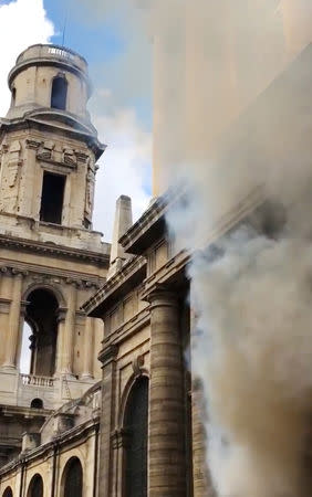 A smoke rises from Saint-Sulpice church in Paris, France, March 17, 2019 in this still image taken from a social media video obtained on March 18, 2019. INSTAGRAM @agneswebste/via REUTERS