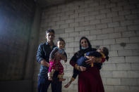 Syrian refugees Raed Mattar, 24, left, poses for a photograph with his wife Ayesha al-Abed, 21, and their daughters Rahaf, 6 years old, right, and Rayan, 18 months old, at an informal refugee camp, in the town of Rihaniyye in the northern city of Tripoli, Lebanon, Tuesday, April 13, 2021. For many Syrian refugee families in Lebanon, Ramadan comes as a hard life of displacement has gotten even harder after a pandemic year that deepened economic woes in their host country. (AP Photo/Hassan Ammar)