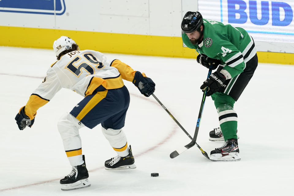 Nashville Predators defenseman Roman Josi (59) and Dallas Stars left wing Jamie Benn (14) compete for control of the puck in the first period of an NHL hockey game in Dallas, Friday, Jan. 22, 2021. (AP Photo/Tony Gutierrez)