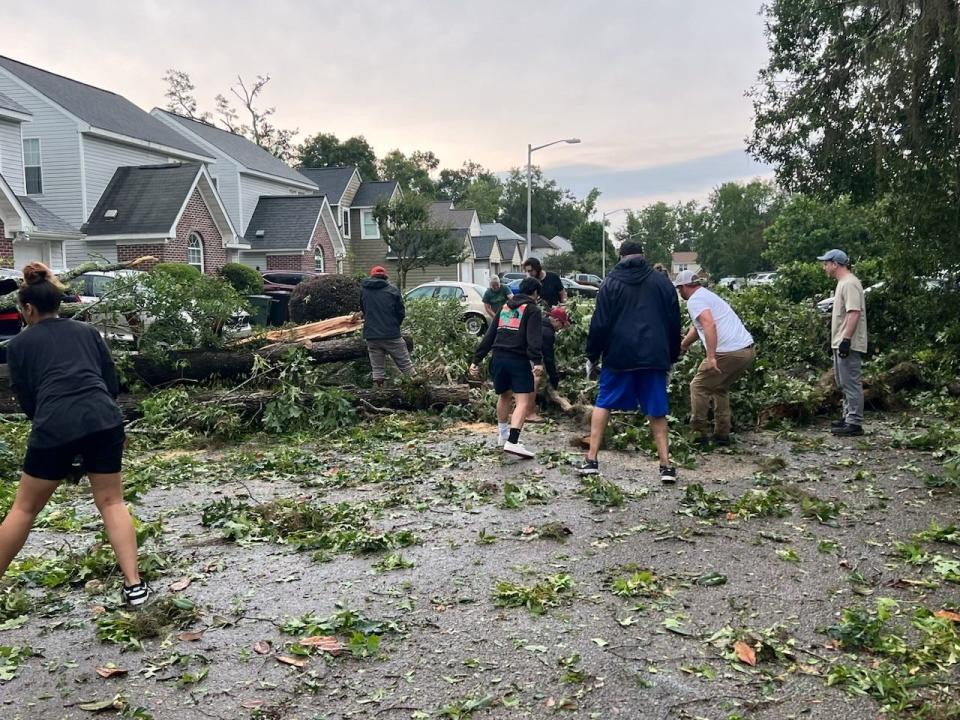 Residents work together on a hard-hit area off Old St. Augustine Road that was blocked from both ends after severe storm Friday, May 10, 2024.