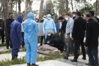 Relatives mourn over the body of Fatemeh Rahbar, a lawmaker-elect from a Tehran constituency, who died on Saturday after being infected with the new coronavirus, at Behesht-e-Zahra cemetery, just outside Tehran, Iran, Sunday, March 8, 2020. Rahbar previously served three terms as lawmaker. With the approaching Persian New Year, known as Nowruz, officials kept up pressure on people not to travel and to stay home. Health Ministry spokesman Kianoush Jahanpour, who gave Iran's new casualty figures Sunday, reiterated that people should not even attend funerals. (Mehdi Khanlari/Fars News Agency via AP)