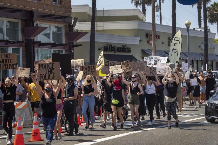 NEWPORT BEACH, CA - JUNE 03: Hundreds of Black Lives Matter supporters march down Balboa Blvd. to protest against racism and Minneapolis police officers' involvement in the May 25 death of George Floyd, an unarmed black man Wednesday, June 3, 2020 in Newport Beach, CA. It was the second of four protests Wednesday in Newport Beach. (Allen J. Schaben / Los Angeles Times)