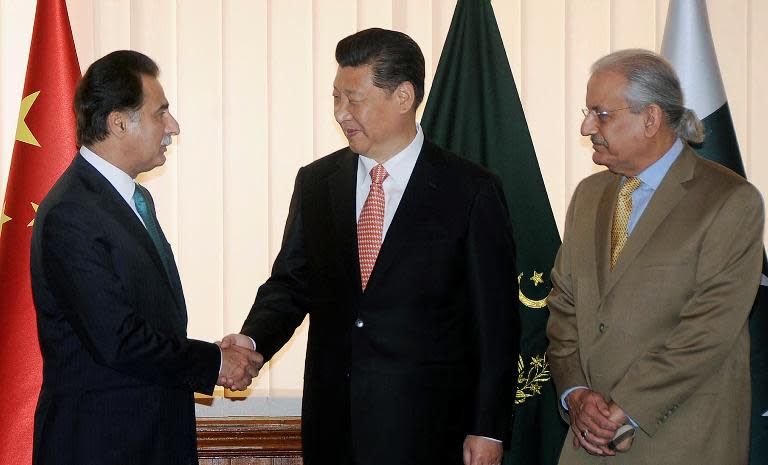 Chinese President Xi Jinping (C) shakes hands with National Assembly Speaker Sardar Ayaz Sadiq (L) as Senate Chairman Mian Rabbani looks on, at Parliament House in Islamabad on April 21, 2015