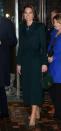 <p>Kate wears an emerald coat over a green-and-blue plaid midi dress by Burberry.</p>