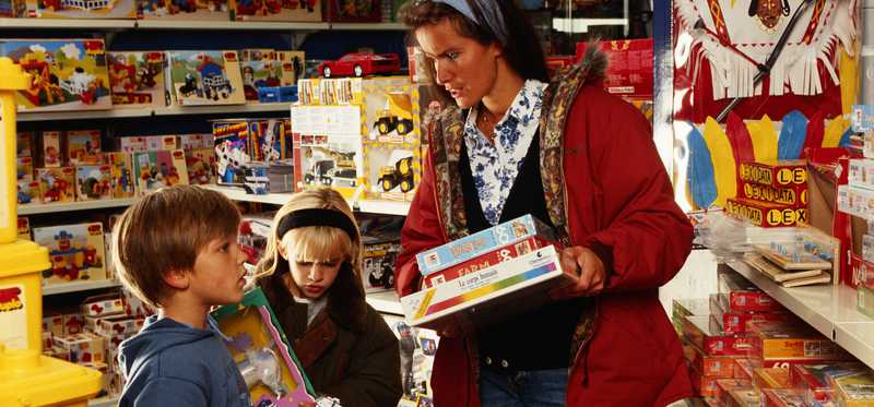 Mother shops with her children in a toy store.