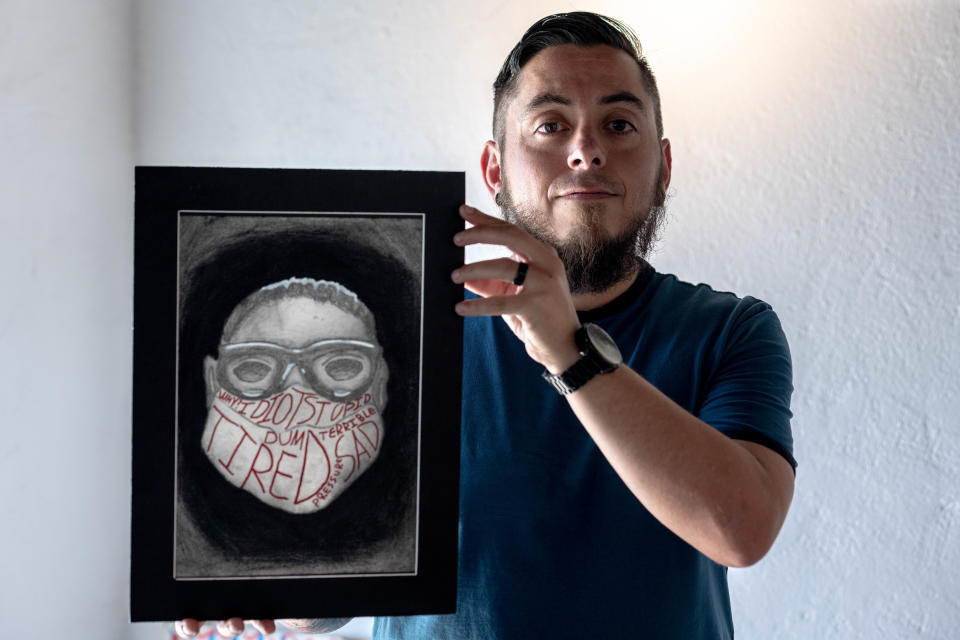Daniel Short, an art teacher at Harmony School of Excellence, holds a self-portrait done by his student Jakob Garcia at Galeria Lincoln on Thursday.