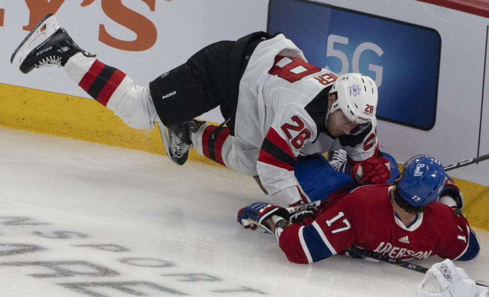 New Jersey Devils' Timo Meier (28) checks Montreal Canadiens' Josh Anderson (17) into the boards during the first period of an NHL hockey game Tuesday, Oct. 24. 2023, in Montreal. (Christinne Muschi/The Canadian Press via AP)