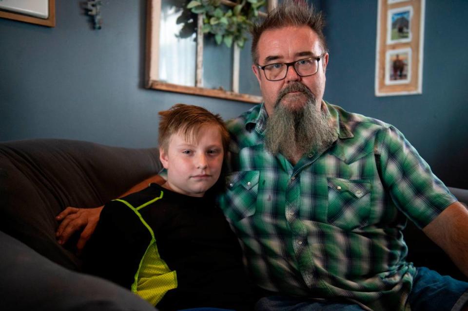 Bill McLarty, right, and his son Chris, 12, at their Jackson County home on Wednesday, June 7, 2023. Bill McLarty wants tougher laws for vicious dogs because Chris has been attacked twice by a neighbor’s pit bull, suffering a severe leg injury the second time. The pit bull still lives a few houses down. Hannah Ruhoff/Sun Herald