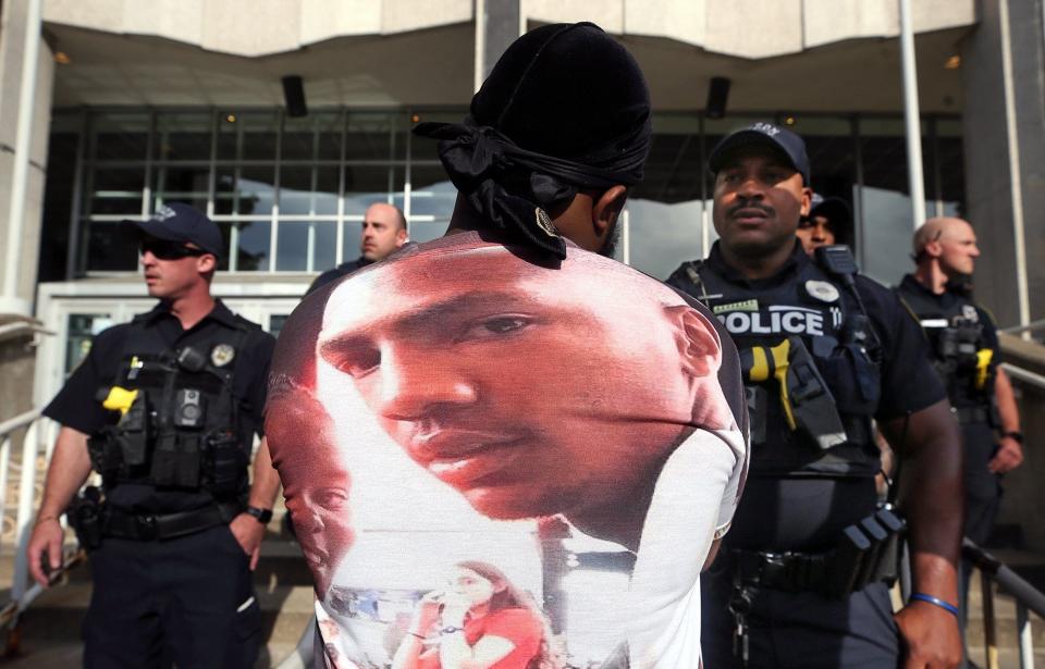 A protester stares down an Akron police officer outside the Harold K. Stubbs Justice Center during a demonstration Saturday over Walker's shooting death by police.