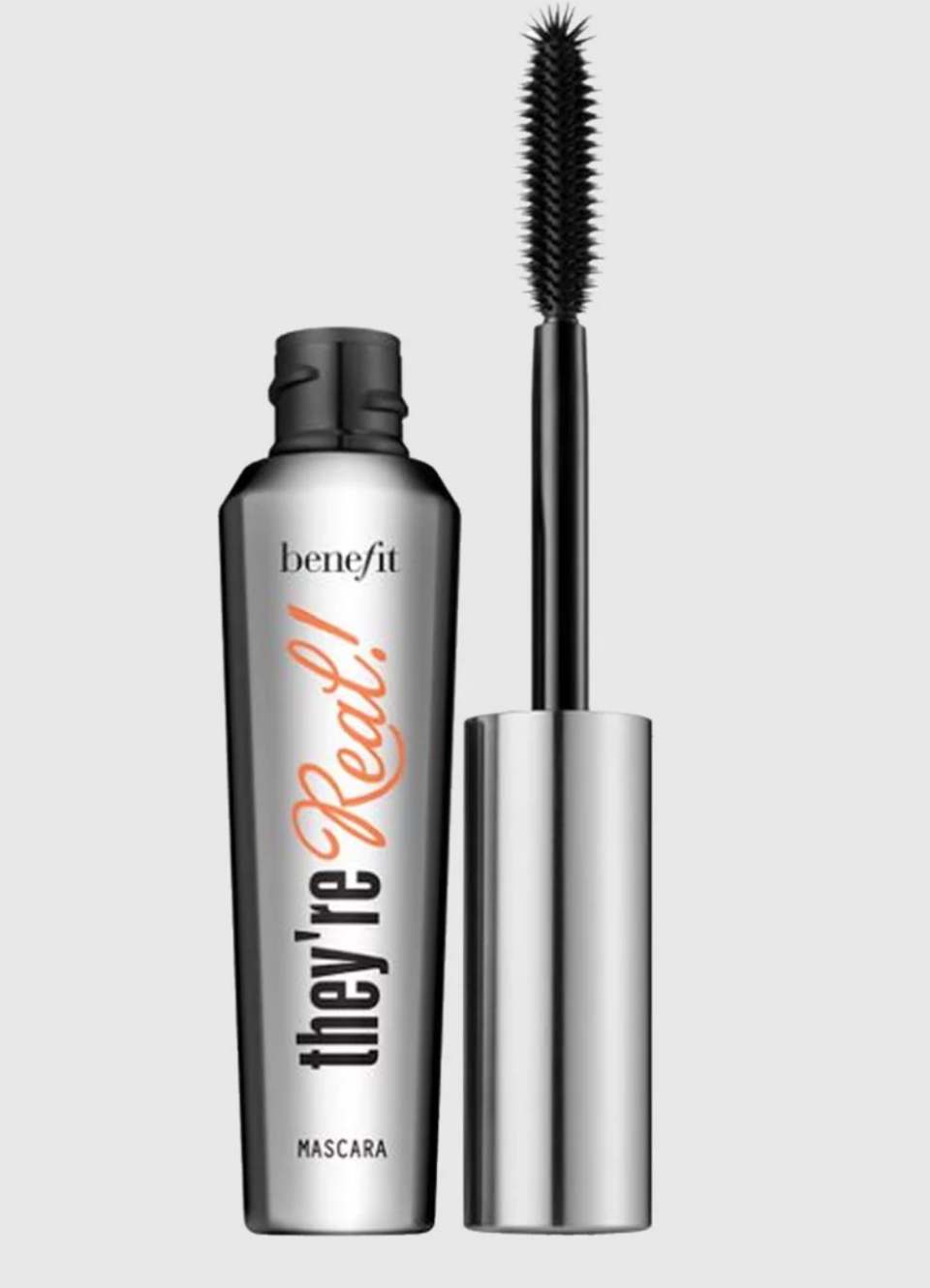 An opened silver tube of mascara with black and orange lettering against a grey background