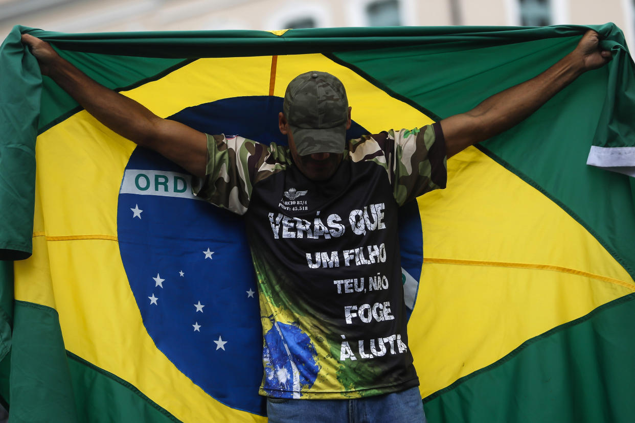 FILE - A supporter of President Jair Bolsonaro holds a Brazilian national flag during a protest against his defeat in the presidential runoff election, in Rio de Janeiro, Brazil, Nov. 2, 2022. Thousands of supporters called on the military to keep the far-right leader in power, even as his administration signaled a willingness to hand over the reins to his rival Luiz Inacio Lula da Silva. (AP Photo/Bruna Prado, File)