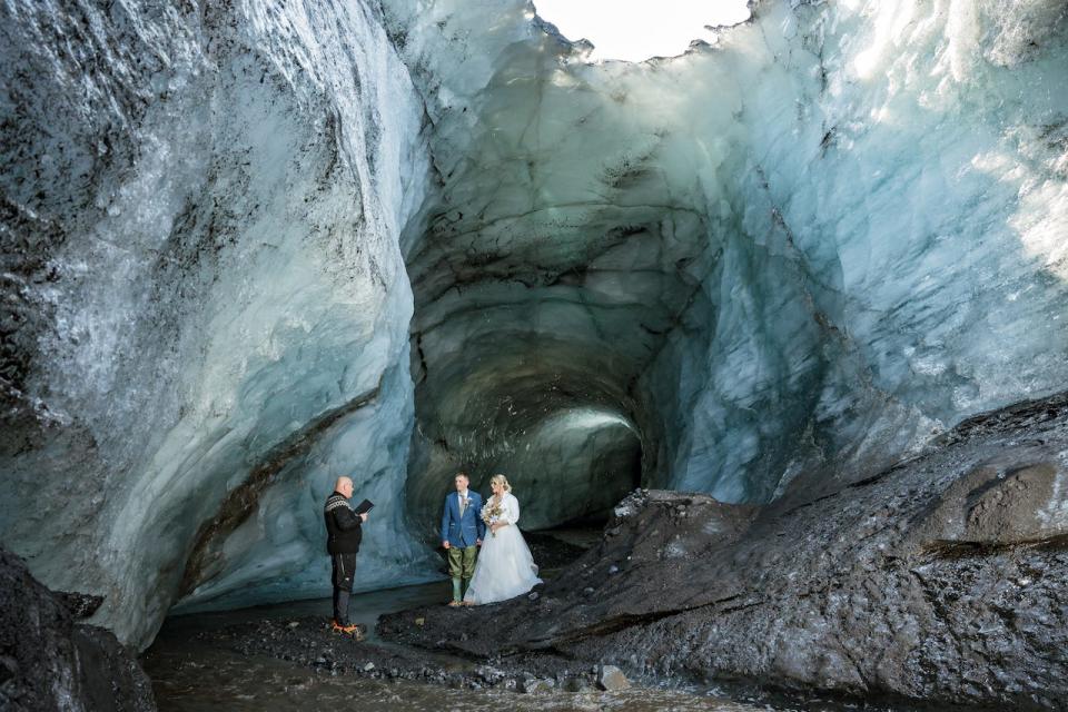 A bride and groom getting married in an ice cave in Iceland.