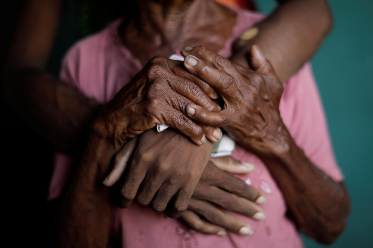 The hands of Aidalis Guanipa, 25, a kidney disease patient, and her 83-year-old grandmother, are seen as the two women pose for a photo; the women waiting for the electricity to return at Guanipa's house during a blackout in La Concepción, Venezuela. (Photo: Ueslei Marcelino/Reuters)