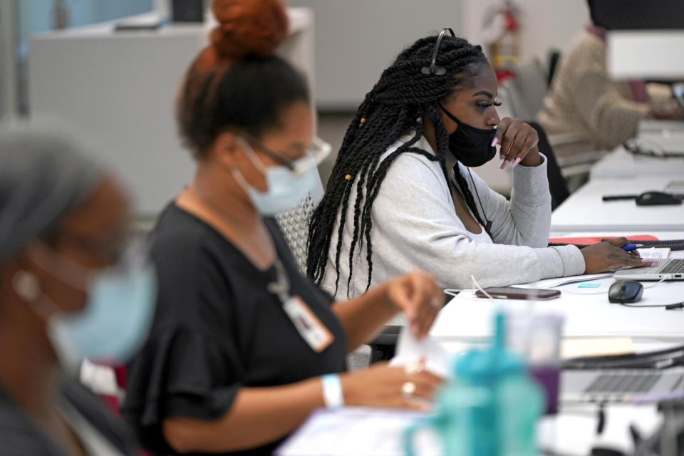 Contact tracer Kandice Childress, right, works at Harris County Public Health contact tracing facility, Thursday, June 25, 2020, in Houston. Texas Gov. Greg Abbott said Wednesday that the state is facing a "massive outbreak" in the coronavirus pandemic and that some new local restrictions may be needed to protect hospital space for new patients. (AP Photo/David J. Phillip)