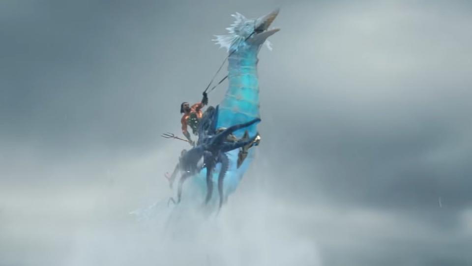 Aquaman riding a giant blue translucent seahorse with a sea animal holding on to it