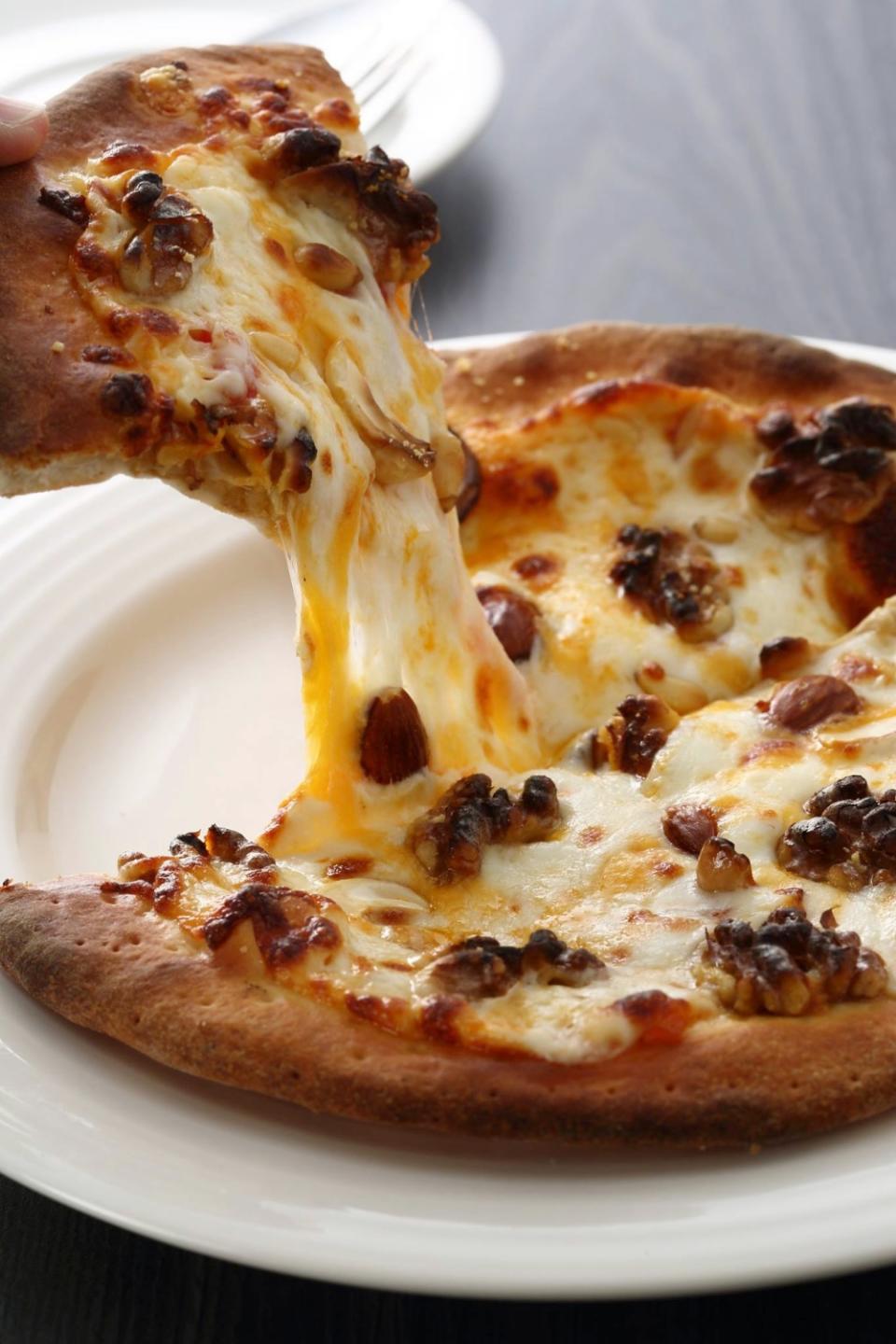 烤得金黃香酥的餅皮、牽絲的頂部餡料，正是麥香園手做披薩的魅力。
