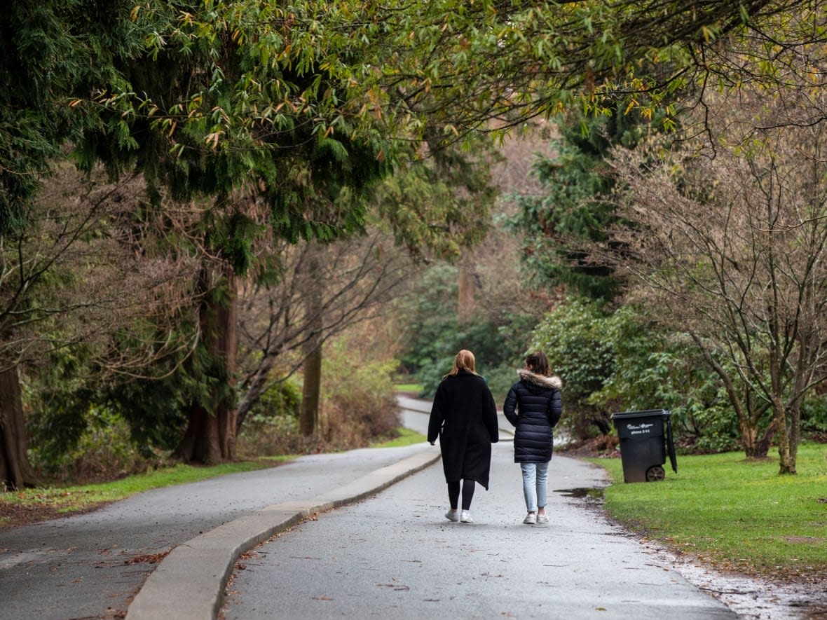 Two people walk along a trail near Lost Lagoon in Vancouver, B.C. A growing body of research on the health benefits of nature has led to the creation of PaRx, which lets health-care professionals prescribe spending time in nature as a way to improve physical and mental health. (Ben Nelms/CBC - image credit)