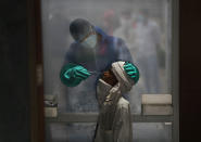 A health worker takes a nasal swab of a person for a COVID-19 test at a hospital in New Delhi, India, Monday, July 6, 2020. India has overtaken Russia to become the third worst-affected nation by the coronavirus pandemic. (AP Photo/Manish Swarup)