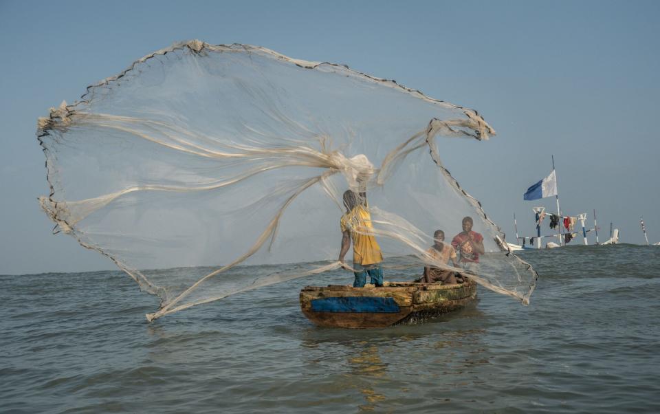 A fisherman casts his net in the waters of the Gulf of Guinea, outside Jamestown - NATALIJA GORMALOVA/AFP/Getty Images