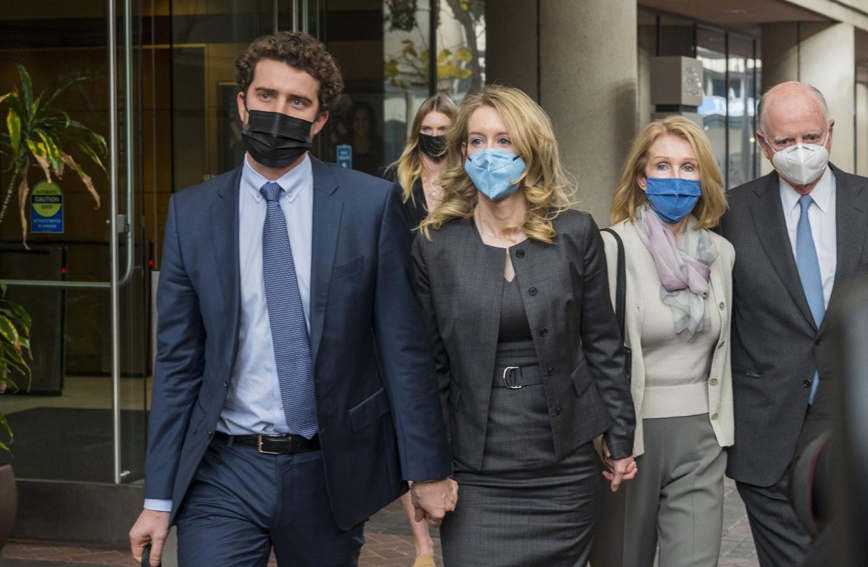 Elizabeth Holmes, center, leaves federal court in San Jose, Calif., Jan. 3, 2022.