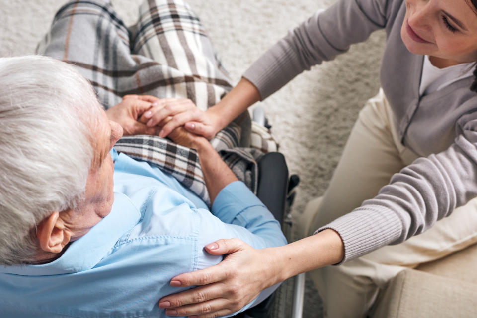 A young woman caring for an old man