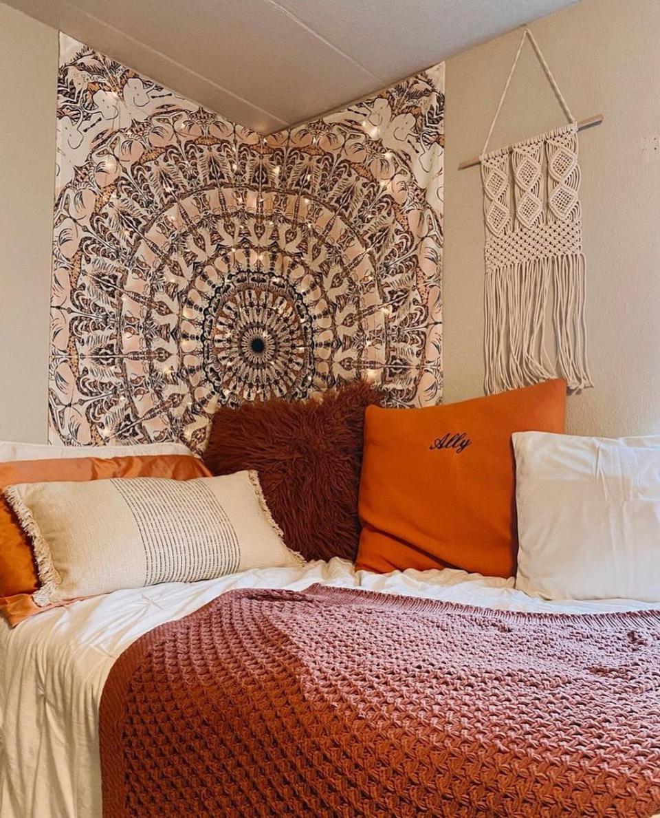 Bedroom with colorful tapestry on wall with string lights