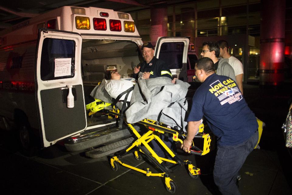 Medical workers assist a patient into an ambulance during an evacuation of New York University Tisch Hospital, after its backup generator failed when the power was knocked out by a superstorm, Monday, Oct. 29, 2012, in New York. Dozens of ambulances lined up outside NYU Tisch Hospital on Monday night as doctors and nurses began the slow process of taking people out. (AP Photo/John Minchillo)