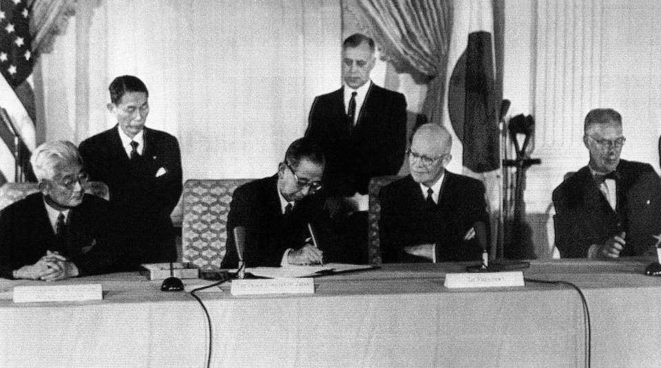 Japan's Prime Minister Nobusuke Kishi signs the U.S.-Japan mutual security treaty, on Jan. 19, 1960, in Washington. From left to right are: Foreign Minister Fujiyama, Kishi, President Dwight D. Eisenhower and Secretary of State Christian Herter. (AP Photo)