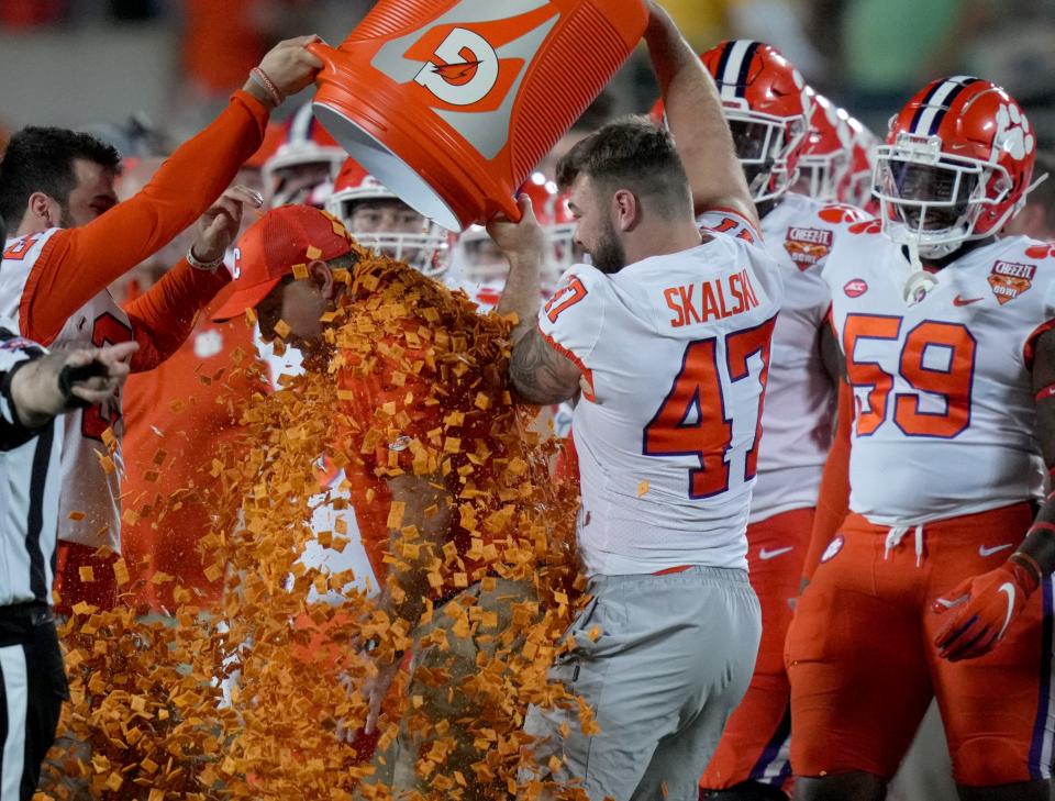 Clemson safety Nolan Turner (24) and linebacker James Skalski (47) pour Cheez-Its on head coach Dabo Swinney after the Tigers' win over Iowa State.