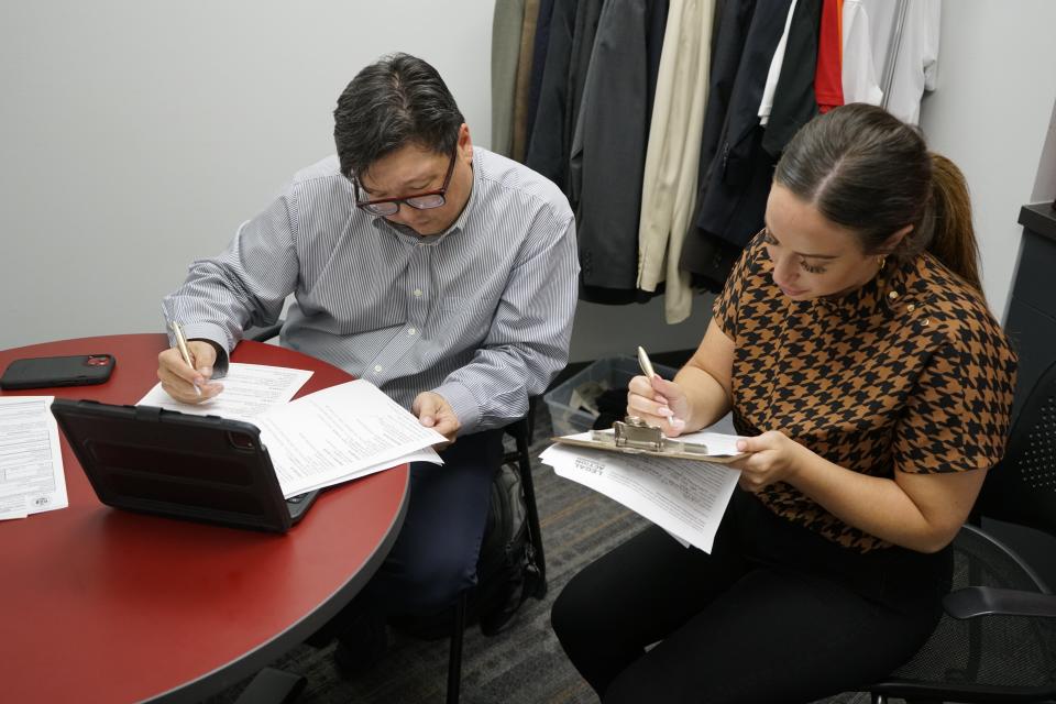 Michael Yang, a private criminal defense attorney, works with Emma Wexler, a paralegal for Alliant Energy, on casework for a client during a free expungement clinic event at Urban League of Greater Madison's Southwest Madison Employment Center on August 10, 2023.