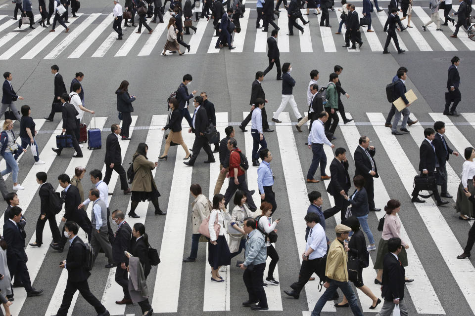 In this April 15, 2019, photo, people cross the street in Tokyo. The Japanese government says the economy grew at an annual pace of 2.1% in the first quarter, marking the second straight quarter of expansion. The Cabinet Office said Monday, May 20, 2019, seasonally adjusted real gross domestic product, the total value of a nation’s goods and services, grew 0.5% in the January-March period from the previous quarter. (AP Photo/Koji Sasahara)