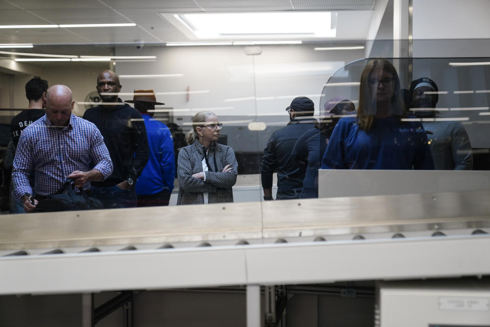 People wait for their belongings at the Transportation Security Administration security area at the Hartsfield-Jackson Atlanta International Airport on Wednesday, Jan. 25, 2023, in Atlanta. (AP Photo/Brynn Anderson)