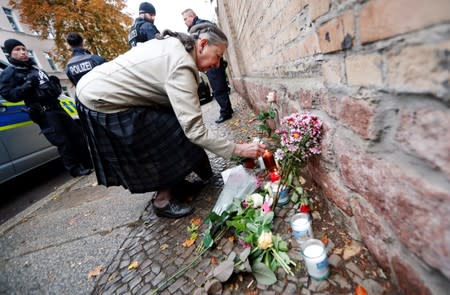Woman lights a candle outside the synagogue in Halle