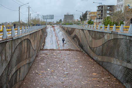 A man walks near a tunnel filled with water after a flash flooding in Shiraz, Iran, March 26, 2019. Tasnim News Agency/via REUTERS