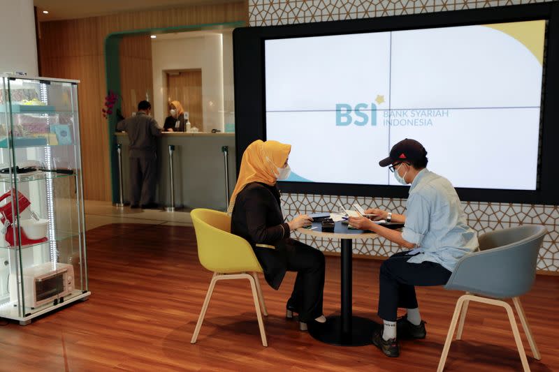 FILE PHOTO: Bank workers serve customers at Bank Syariah Indonesia in Jakarta