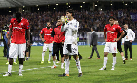 Soccer Football - Champions League Playoffs - Maribor v Hapoel Be'er-Sheva - Maribor, Slovenia - August 22, 2017 Hapoel Be'er Sheva's Guy Haimov applauds the fans as John Ogu (L) and Elyaniv Barda (R) look dejected at the end of the match REUTERS/Srdjan Zivulovic