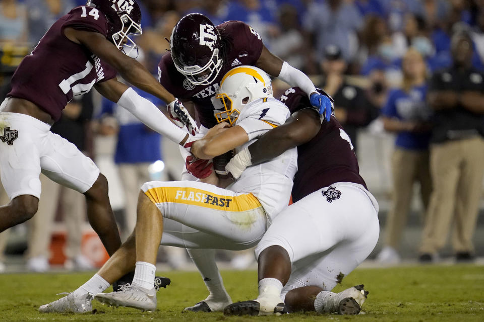 Kent State quarterback Dustin Crum (7) is tackled by Texas A&M defensive lineman Isaiah Raikes (34) and defensive back Leon O'Neal Jr. (9) after a short run during the first half of an NCAA college football game on Saturday, Sept. 4, 2021, in College Station, Texas. (AP Photo/Sam Craft)